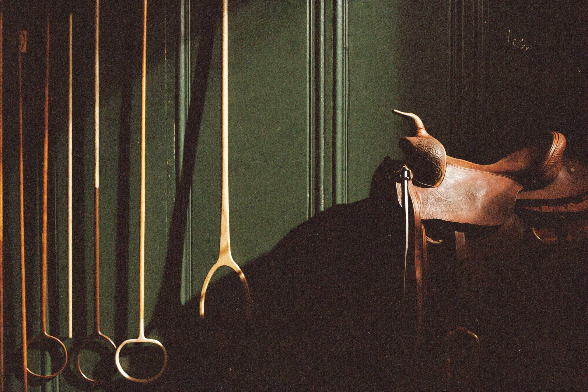 Polo mallets against a green wall